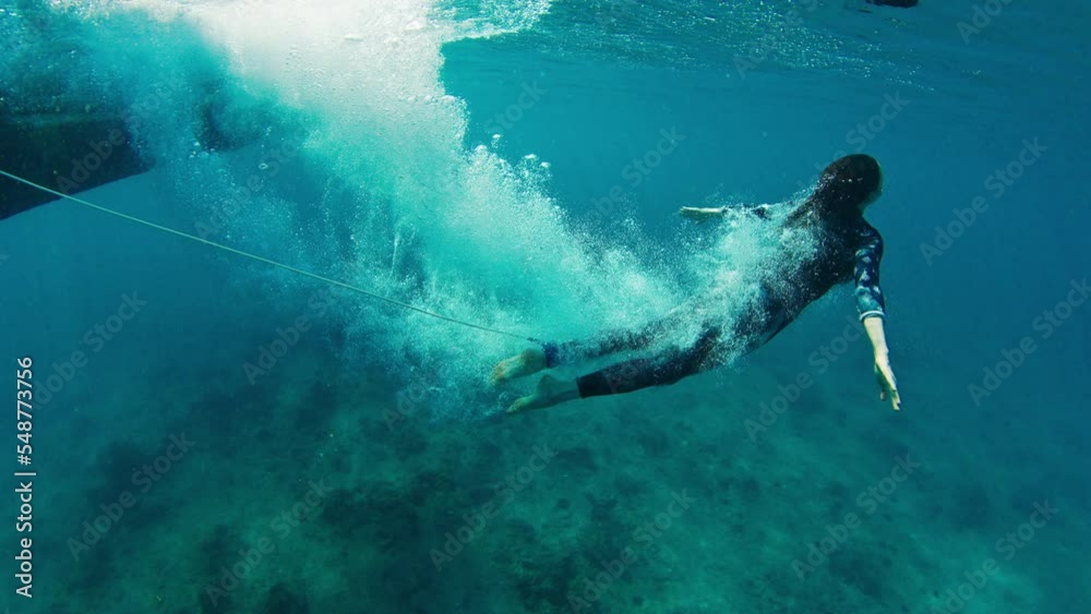 Woman surfer jumps from the boat into the water