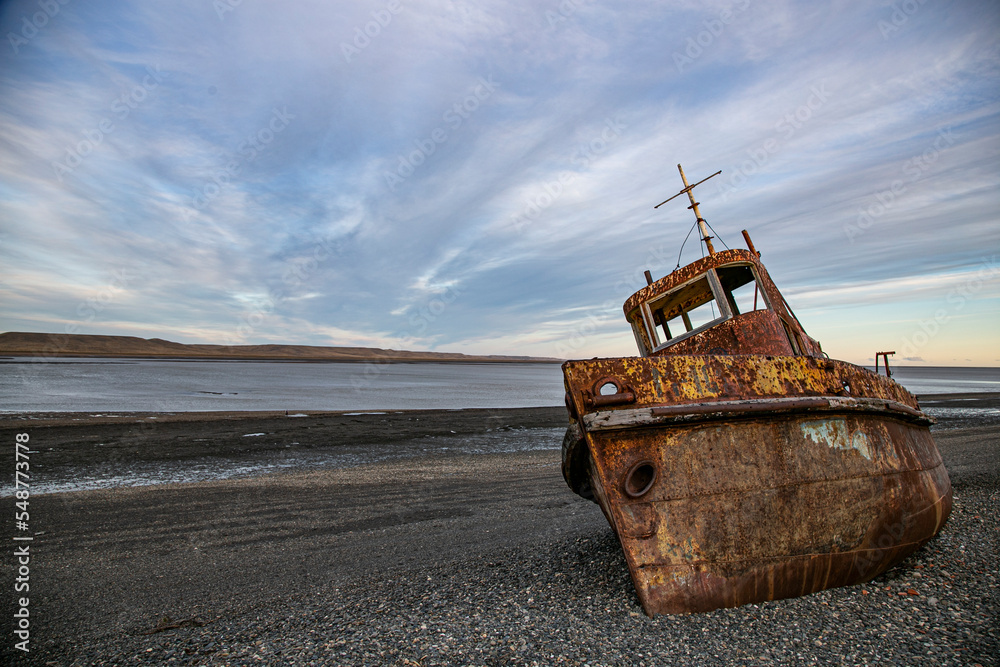 Weathered Hull of an Old Tugboat Stranded Along the Patagonian Riverbank
