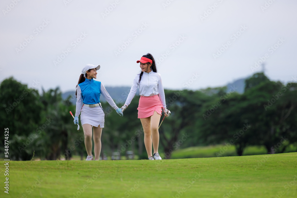 Two young asian professional golfers walking hand in hand and talk about like friend and smiling happily on the golf course,. Two young asian professional golfers walking hand in hand and talk about like friend and smiling happily on the golf course,.