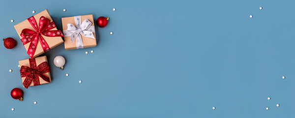 Gift boxes with Christmas decorations on blue background. Top view.