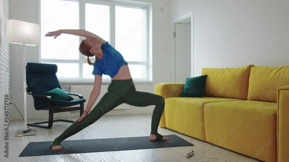 Adult skinny woman doing yoga exercises in the living room Adult skinny woman doing yoga exercises in the living room