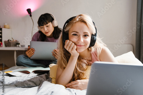 Young beautiful smiling girl in headphones propping her head