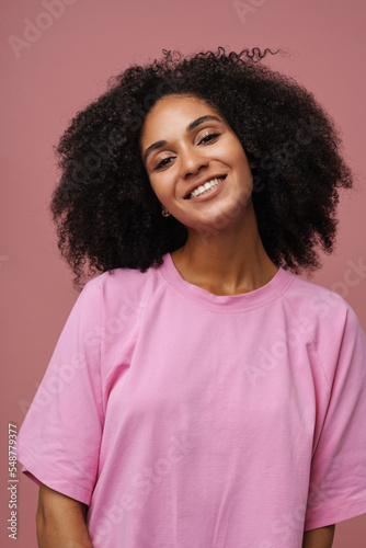 Portrait of young beautiful smiling curly woman looking at camera © Drobot Dean