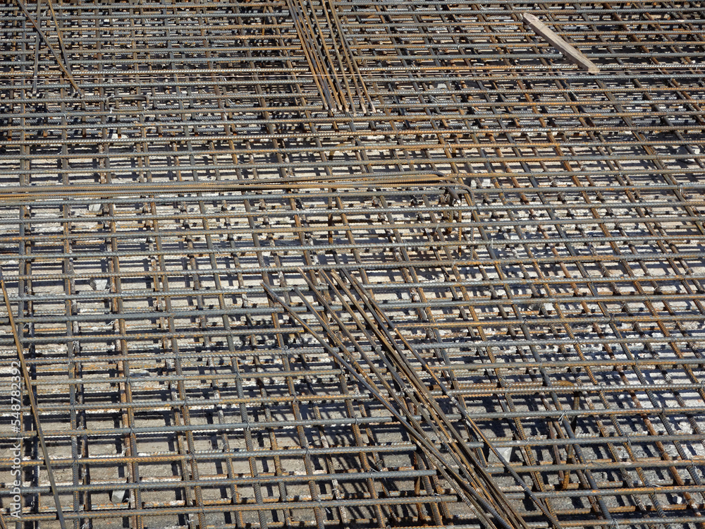 Fototapeta premium MELAKA, MALAYSIA -JULY 2, 2022: Steel reinforcement bars are arranged according to the structural engineer's design. The steels are tied together using a small steel wire.