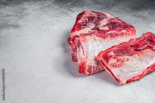 Beef Short Ribs, raw meat on kitchen table. White background. Top view. Copy space