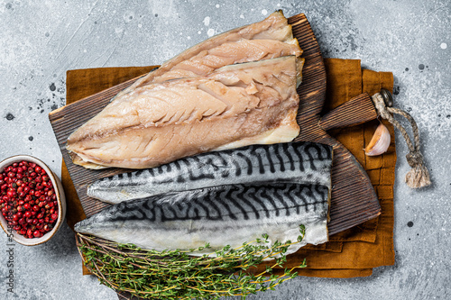 Cooking of fresh raw mackerel fillet fish on a cutting board. Gray background. Top view