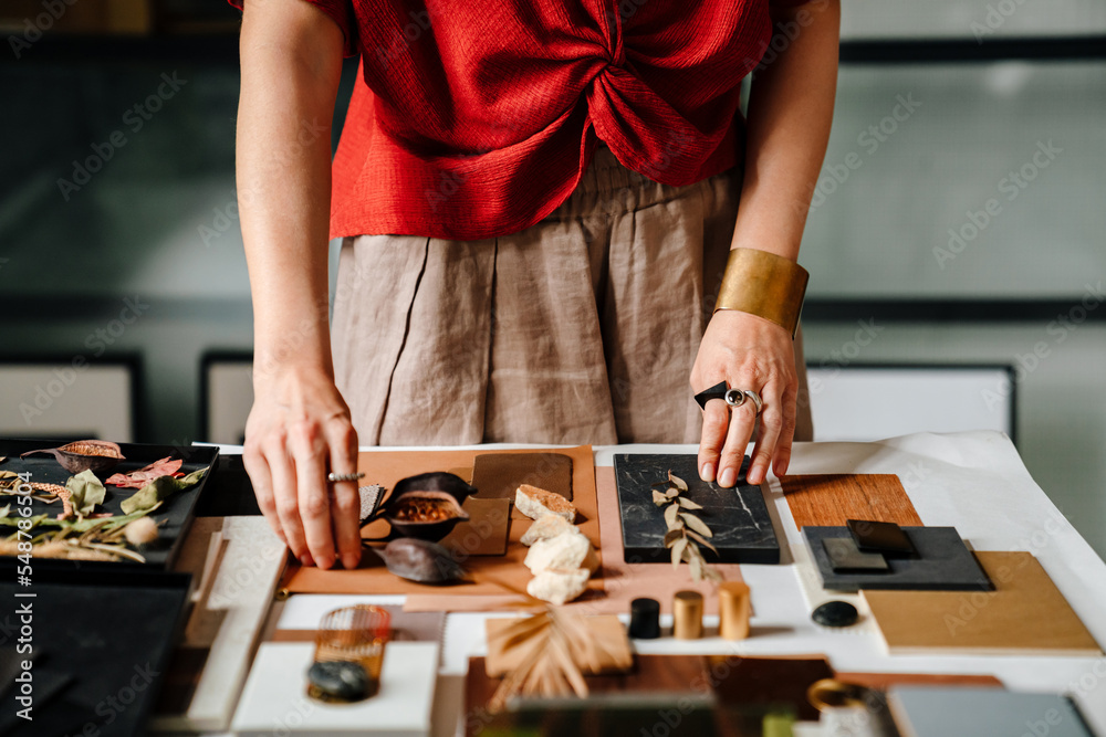 © Drobot Dean - Close up of female interior designer working at her workshop
