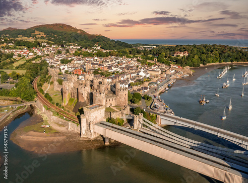 Aerial view with Conwy town and the medieval castle, the famous landmark of Wales and UK, captured at sunset