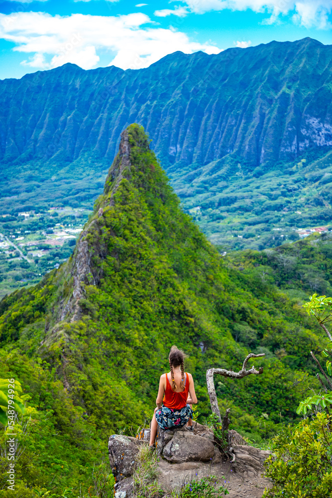 hiker girl stands at the top of olomana ridge trail admiring the panorama of oahu and hawaii mountains; famous three peaks on oahu, dangerous hiking on hawaii mountains, hawaii holidays hiker girl stands at the top of olomana ridge trail admiring the panorama of oahu and hawaii mountains; famous three peaks on oahu, dangerous hiking on hawaii mountains, hawaii holidays