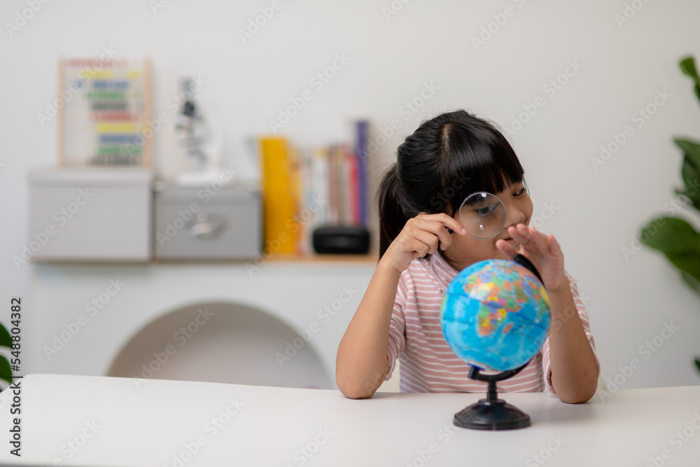 Asian little girl is learning the globe model, concept of save the world and learn through play activity for kid education at home. Asian little girl is learning the globe model, concept of save the world and learn through play activity for kid education at home.