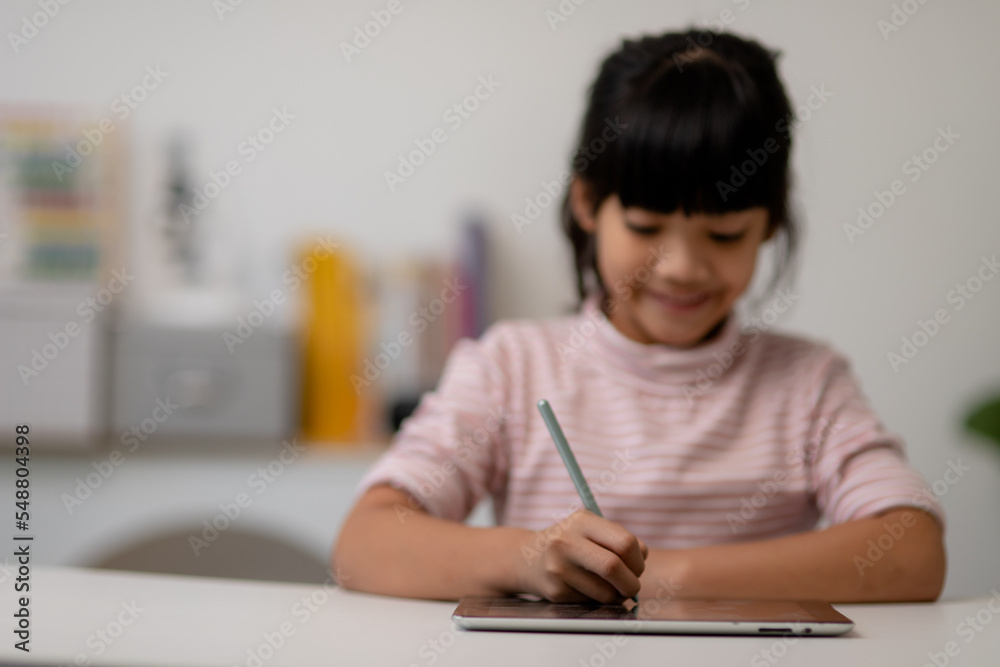 Asian little cute girl touching the digital tablet screen on the table Asian little cute girl touching the digital tablet screen on the table
