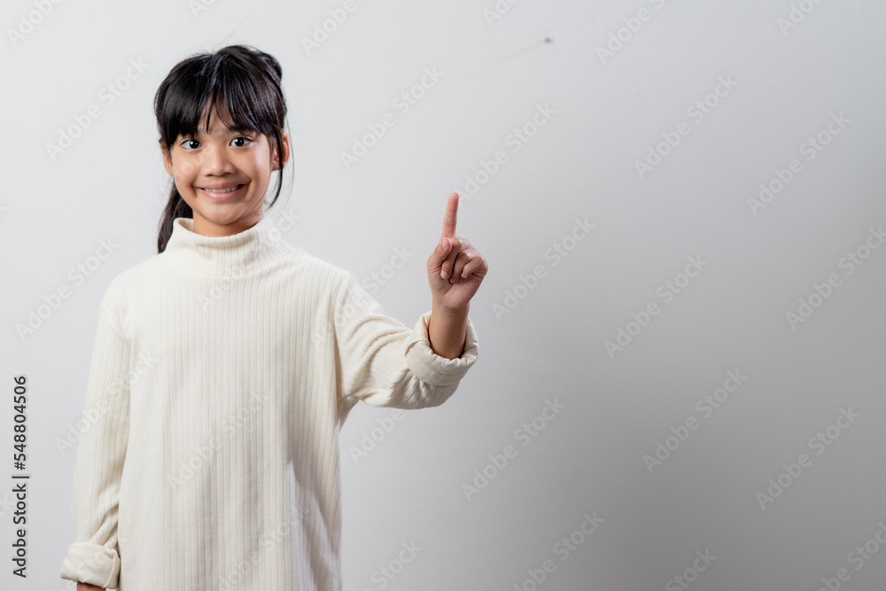 education, school, and imaginary screen concept - Asian little girl pointing in the air or imaginary screen education, school, and imaginary screen concept - Asian little girl pointing in the air or imaginary screen