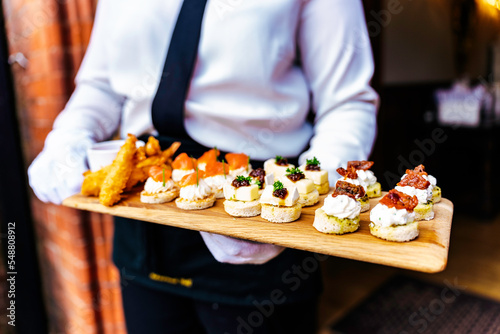 Wedding reception event party catering with appetisers and canapés being served by servers in the garden for their guests