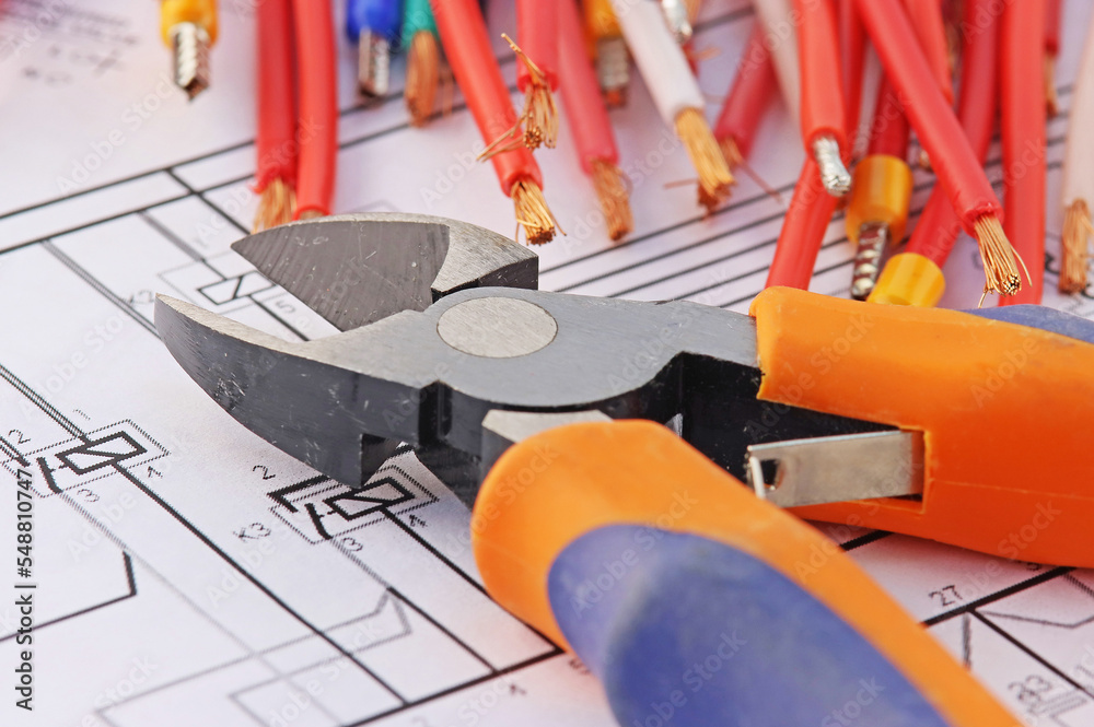 Electrical tools and copper insulated electrical cables. On an electronic diagram.
