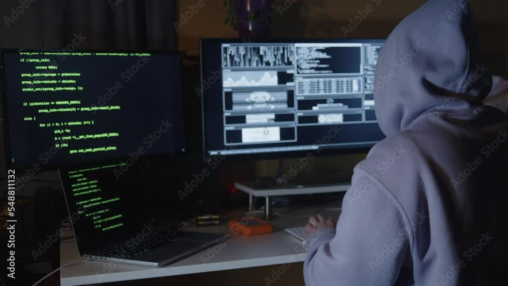 Young hacker, working and hacking with his computers. Attacking systems and danger computering.