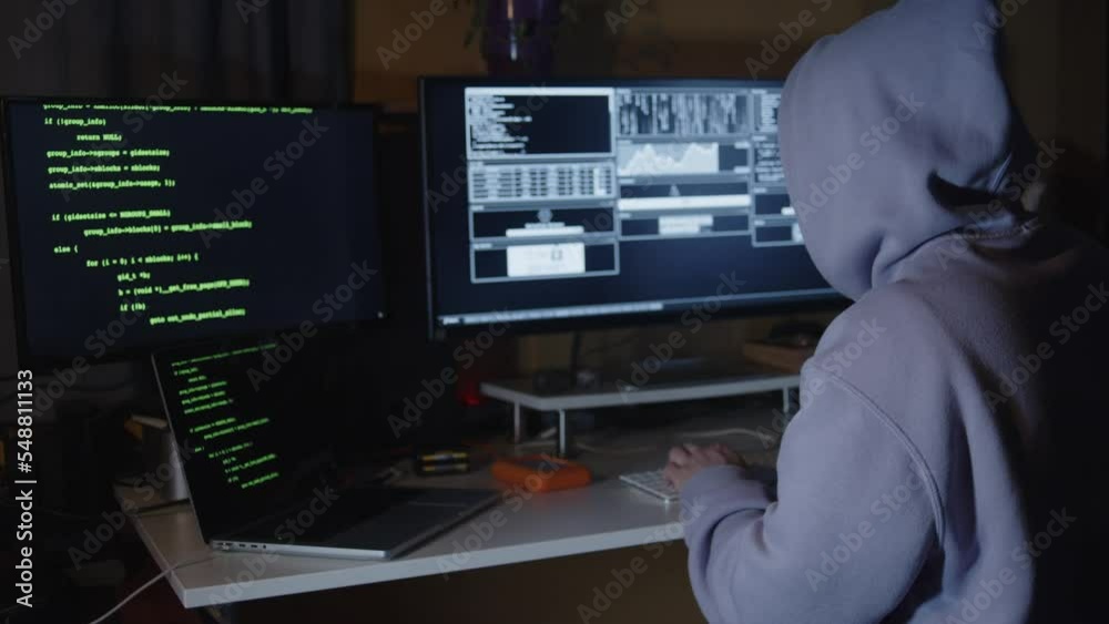 Young hacker, working and hacking with his computers. Attacking systems and danger computering.