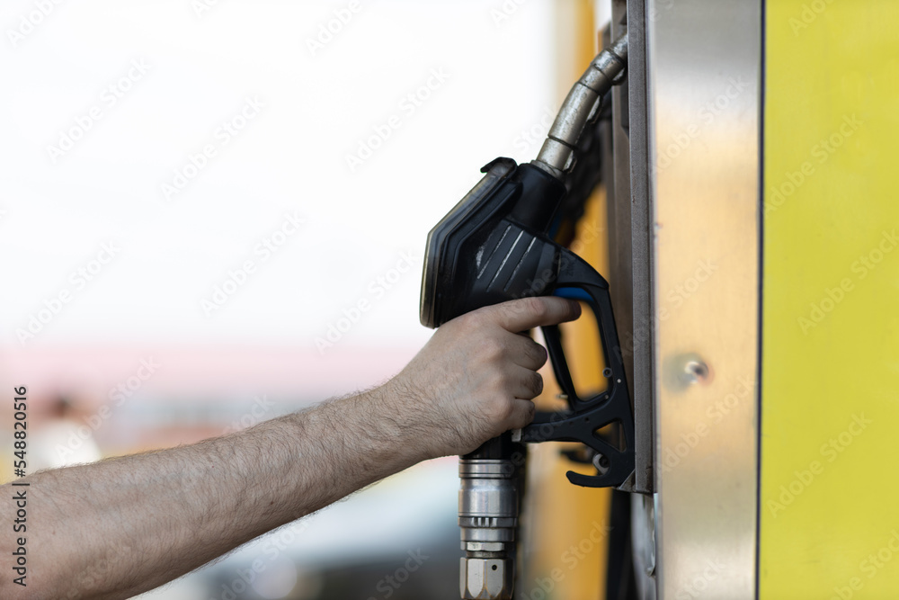 Man holding filling gun in his hand at gas station. Man holding filling gun in his hand at gas station.