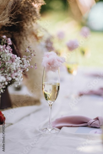 Vertical shot of a glass of champagne with sweet cotton candy at a baby shower.