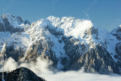 Julian Alps Slovenia, peak Debela Pec 2014 m, winter hiking in Triglav with snowy peaks and mist 