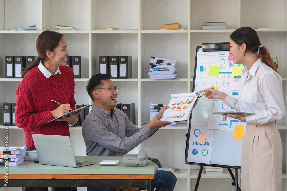 A team of businessmen plan with their laptops and graph charts for their profits and use a calculator to calculate their company's annual balance. A team of businessmen plan with their laptops and graph charts for their profits and use a calculator to calculate their company's annual balance.