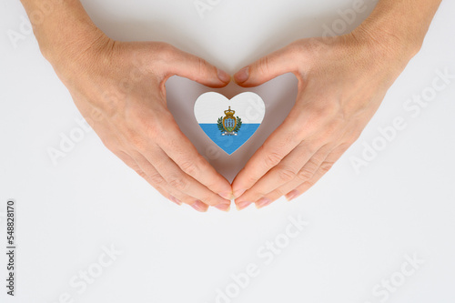 The national flag of the Republic of San Marino in female hands.