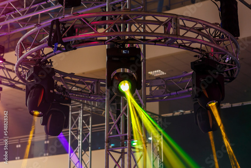 Professional lighting fixtures are suspended on a pole in a circle for a stage platform.