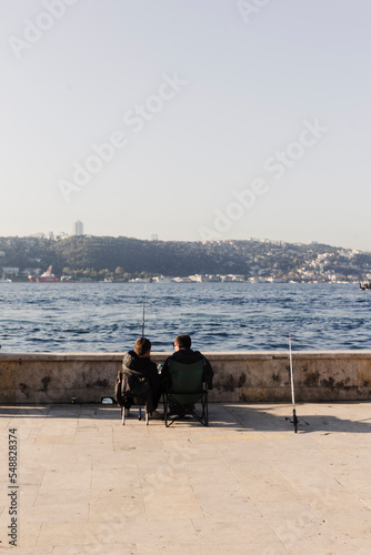 Two men fishing chat and rest in beylerbeyi Istanbul, turkey