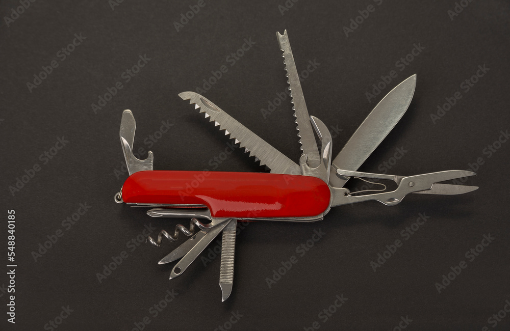 Open swiss army knife on a black background Open swiss army knife on a black background