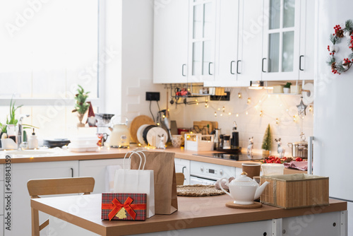 Fotografie Gift box and packages are on kitchen table decorated for Christmas