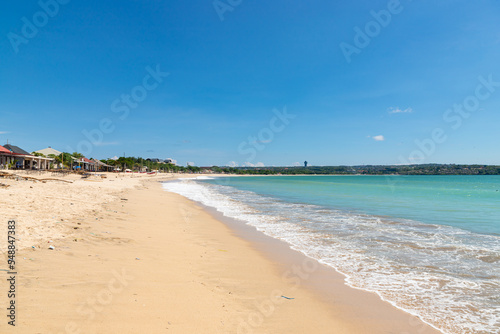 Jimbaran beach with famous fish restaurants in sunny day with blue sky. photo