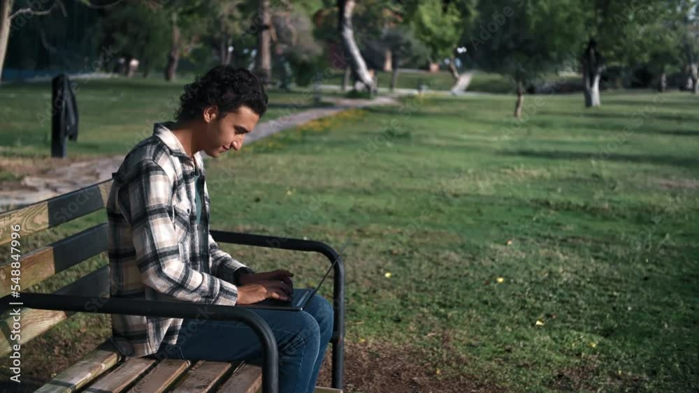 Skilled programmer Arabic man business freelancer working laptop sitting on bench at summer park Skilled programmer Arabic man business freelancer working laptop sitting on bench at summer park