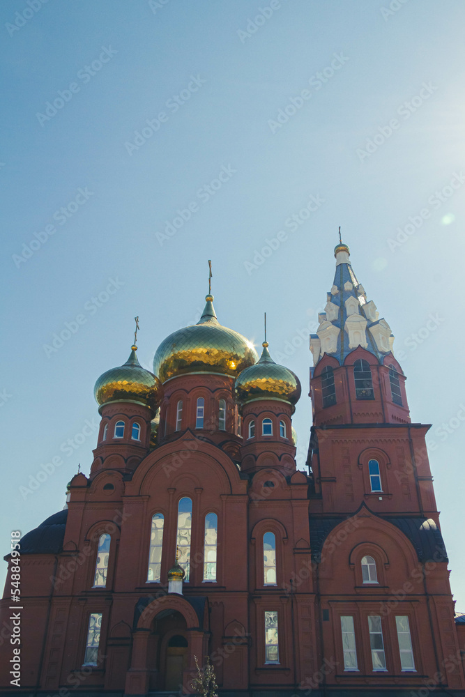 Christian church against blue sky in bright sunlight. Church with dome.