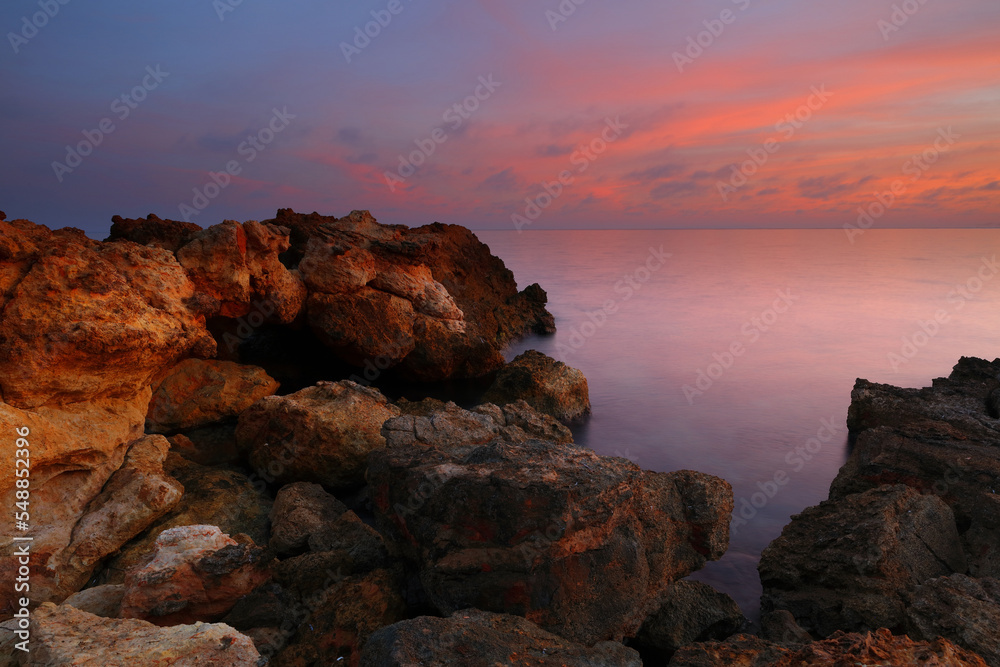 Sunset at Talamanca Beach with limestone rock formations. Santa Eulalia, Ibiza, Spain.