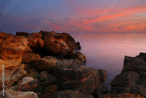 Sunset at Talamanca Beach with limestone rock formations. Santa Eulalia, Ibiza, Spain.