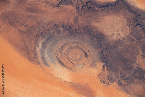 Fototapeta Naklejka Na Ścianę i Meble -  Aerial view of Richat Structure in Mauritania. Also called Guelb er Richât in Arabic Qalb ar-Rīšāt.  Digitally enhanced. The elements of this image furnished by NASA.