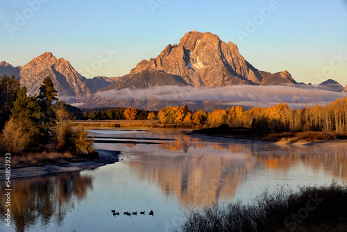 Autumn glow and morning mist at Oxbow Bend in Grand Teton National Park photo