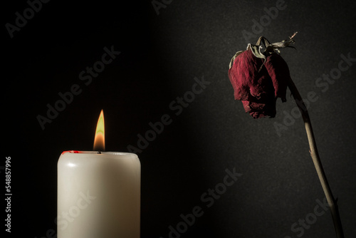 Vela encendida y rosa seca
