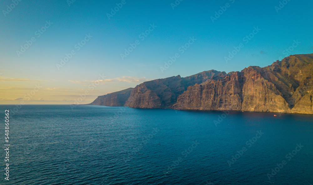 Aerial drone photo of Los Gigantes cliffs during a sunset in Tenerife, Canary Islands. Aerial drone photo of Los Gigantes cliffs during a sunset in Tenerife, Canary Islands.