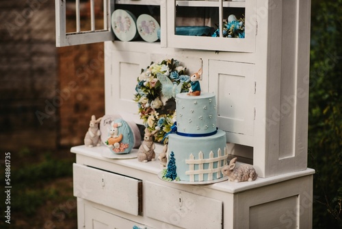 Closeup of a beautifully decorated blue Easter cake on a white shelf