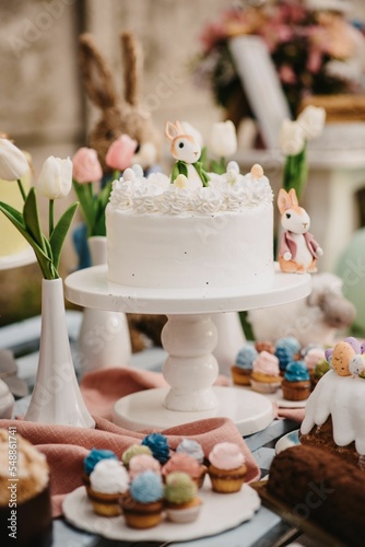 Vertical closeup of a beautifully decorated Easter cake with small cupcakes