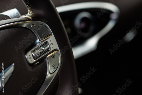 Cruise control switch closeup. Adaptive cruise control leaver. Cruise control on steering wheel. © Roman