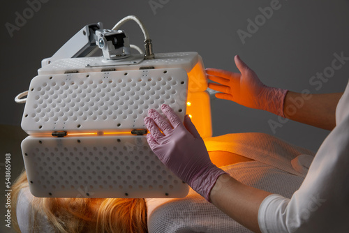 Young woman having photodynamic therapy in beauty salon photo