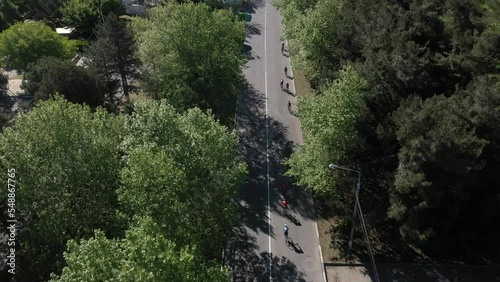 Triathlon, bike ride through the streets of the city. Tracking from a drone of a group of cyclists on a country road. Professional cyclists ride bicycles in bike races.