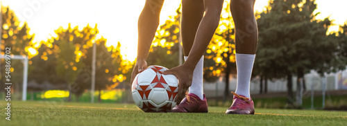 Fotografie Football player placing the ball on the grass