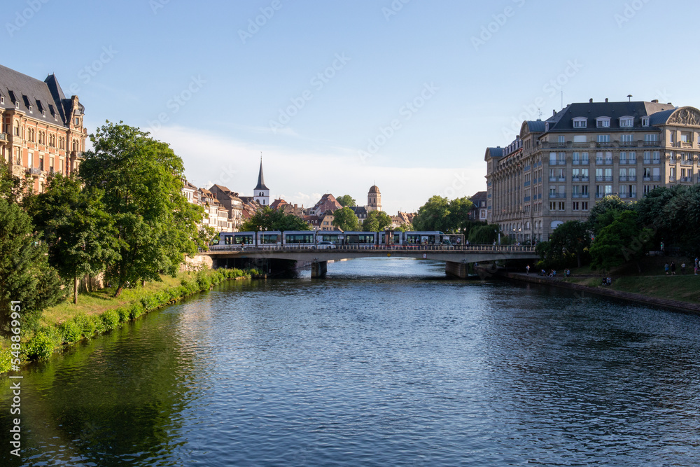 River in a French city over which a bridge with a tram passes