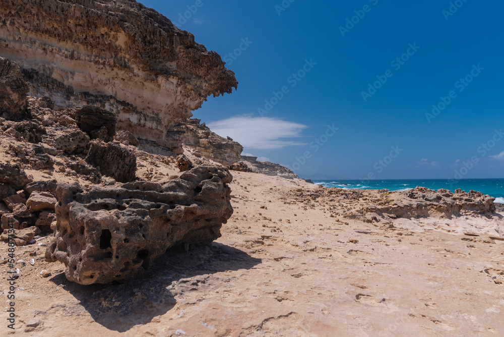 Big dark stone and bright colored rocky desert plateau, west coast, Fuerteventura, Spain