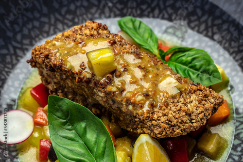 fish fillet breaded in nuts with pepper sauce and vegetables  Food recipe background. Close up