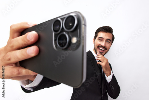 Business man takes selfies on phone with smile with teeth in business suit on white isolated background close-up on wide-angle lens 