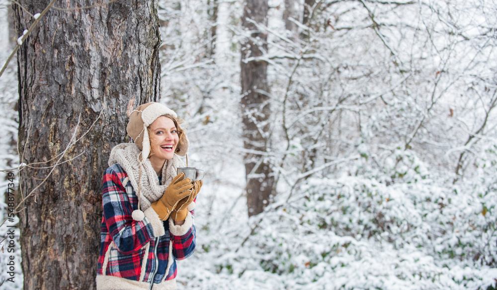 Girl enjoy mulled wine. woman in mittens drinking tea in snowy forest. outdoors on frosty day. travel and hiking. girl hiker drink cup of hot tea. warm yourself up. woman winter drink. copy space Girl enjoy mulled wine. woman in mittens drinking tea in snowy forest. outdoors on frosty day. travel and hiking. girl hiker drink cup of hot tea. warm yourself up. woman winter drink. copy space
