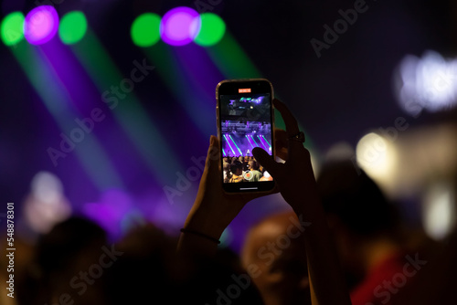 Recording a concert with mobile phone, silhouette of hands with smartphone